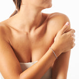 Bracciale indossato con rosario di perline grigie cangianti, realizzato in argento 925